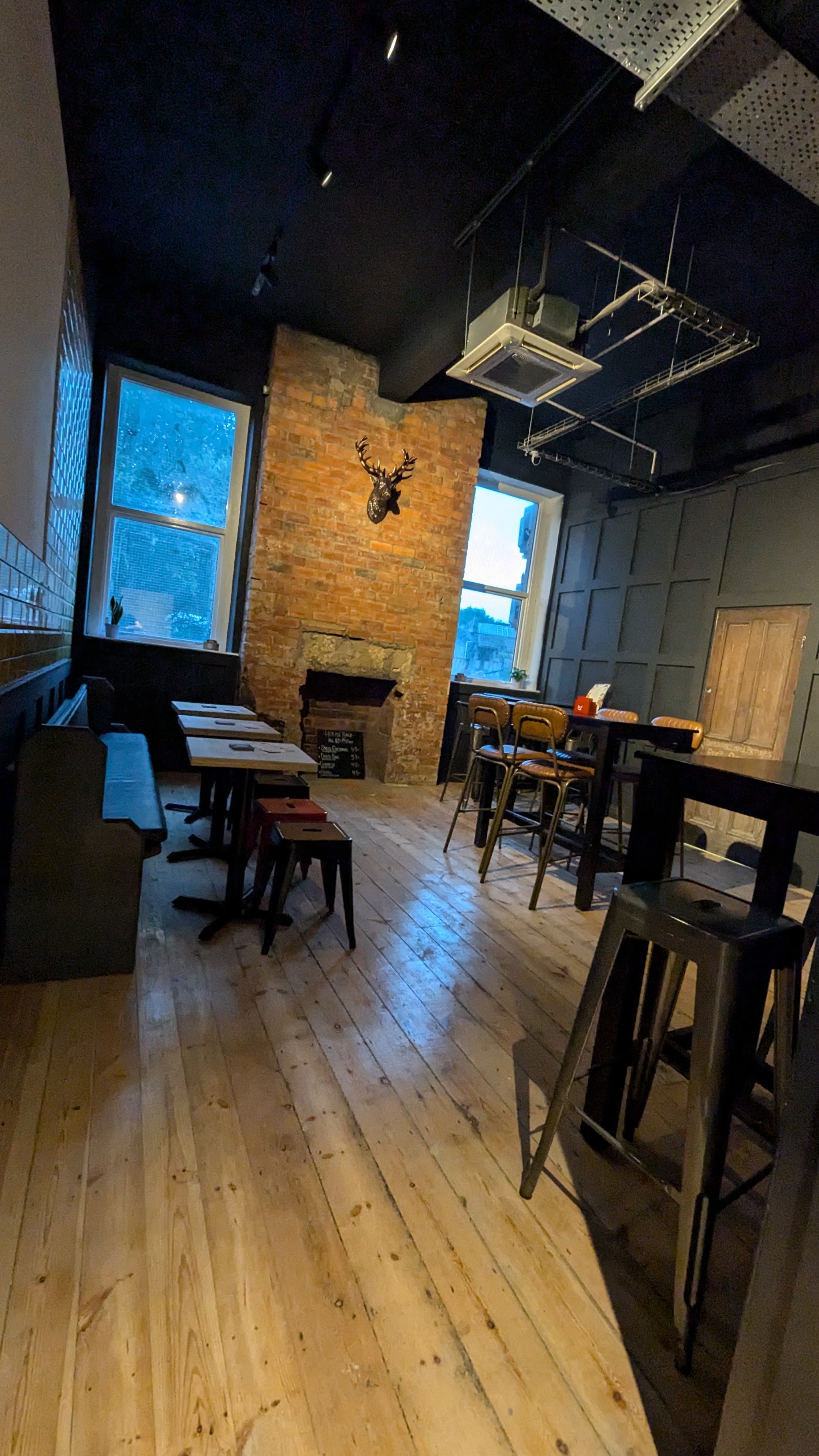Cosy seating beside the brick fireplace and tall windows in the bar